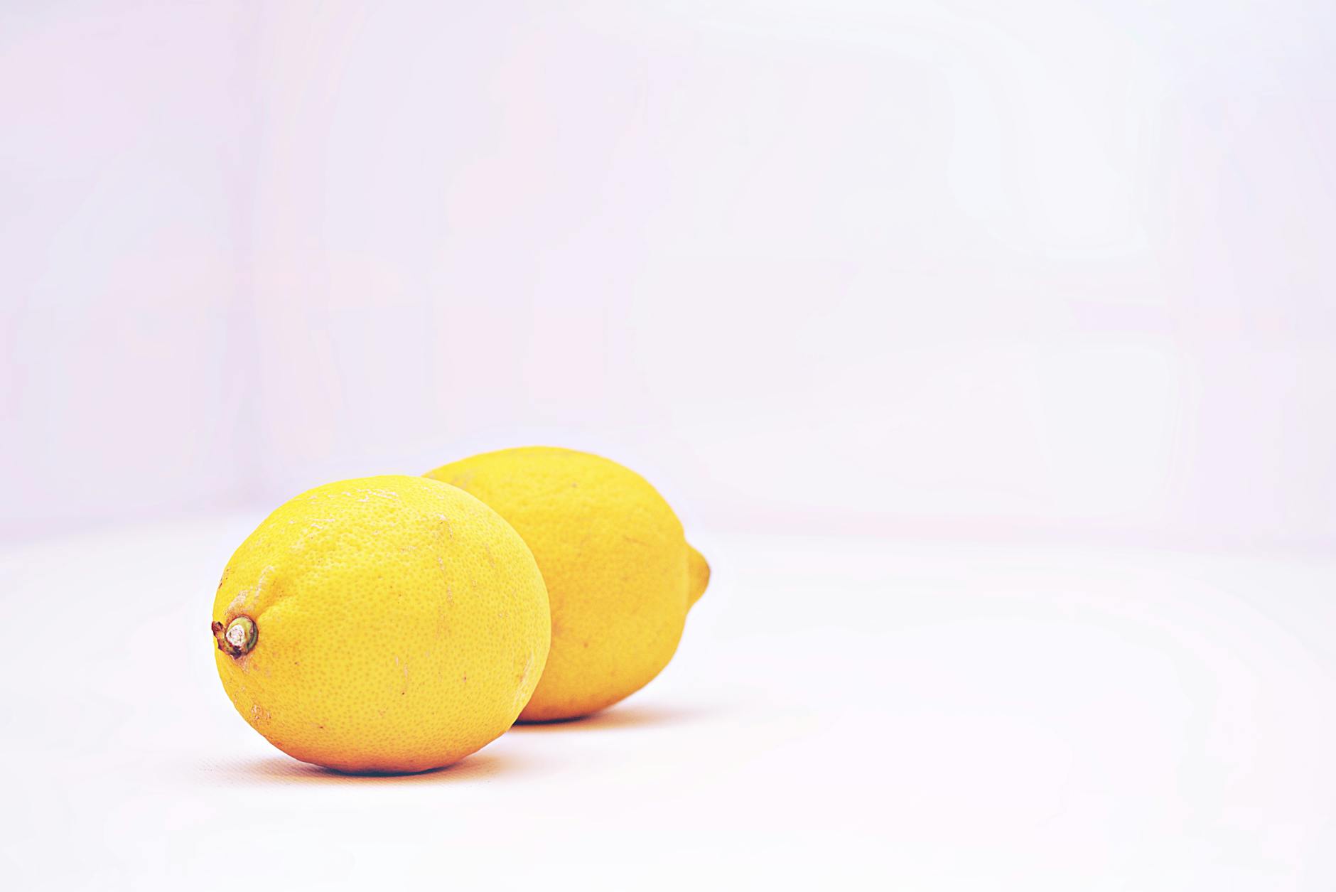 Hand holding a vibrant orange adult toy against a purple backdrop