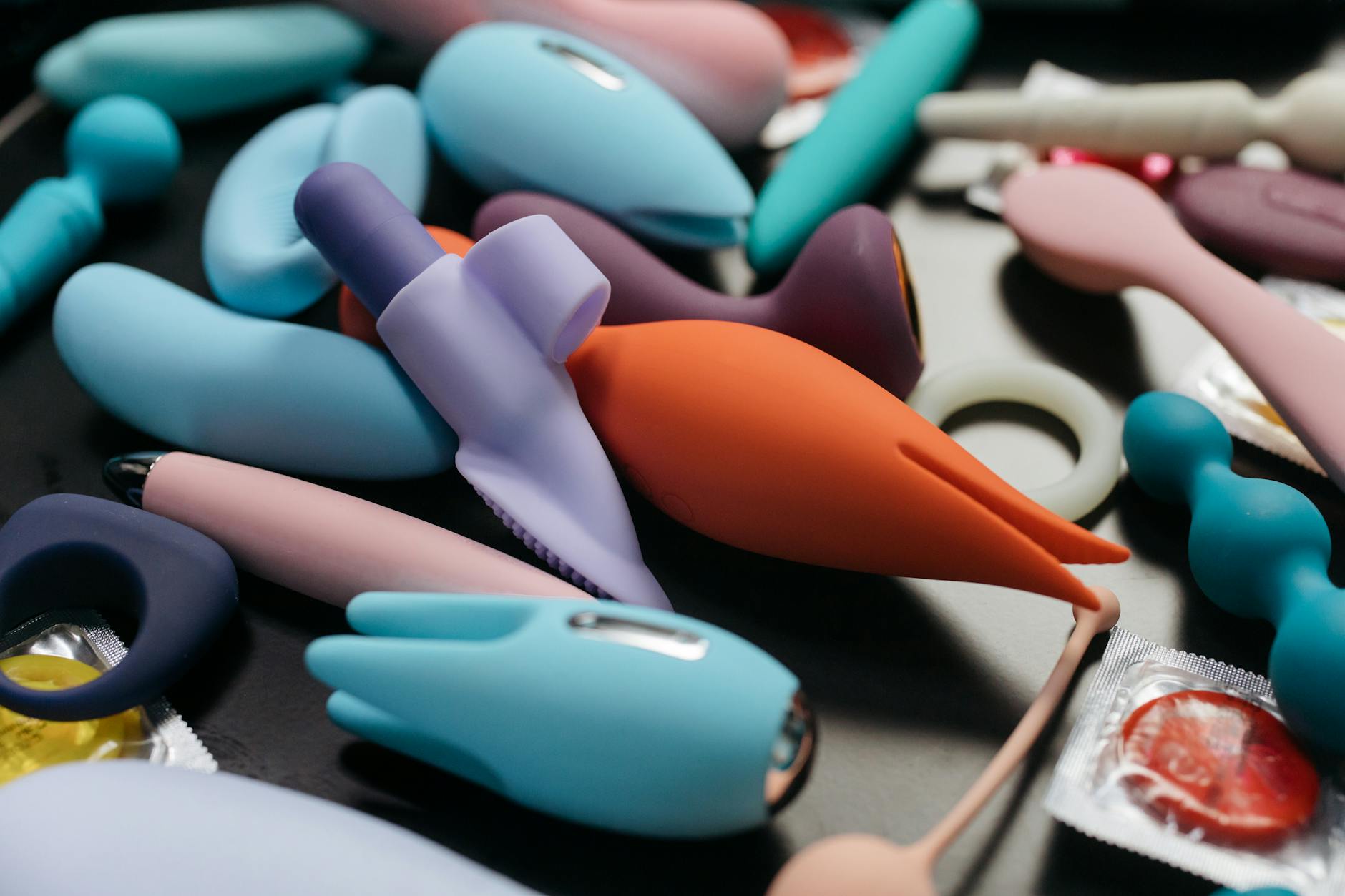 A woman holding a pink vibrator with art books in the background, emphasizing intimate self-knowledge and pleasure